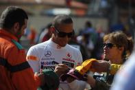 McLaren Mercedes' British driver Lewis Hamilton signs autographs in the pits during first practice session at the Circuit de Monaco on May 24, 2012 in Monte Carlo ahead of the Monaco Formula One Grand Prix. (DIMITAR DILKOFFDIMITAR DILKOFF/AFP/GettyImages)