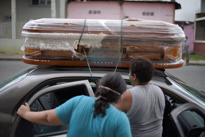 A couple ties an empty coffin to their car to collect the body of a relative as Ecuador's government announced on Thursday it was building a "special camp" in Guayaquil for coronavirus disease (COVID-19) victims, in Guayaquil