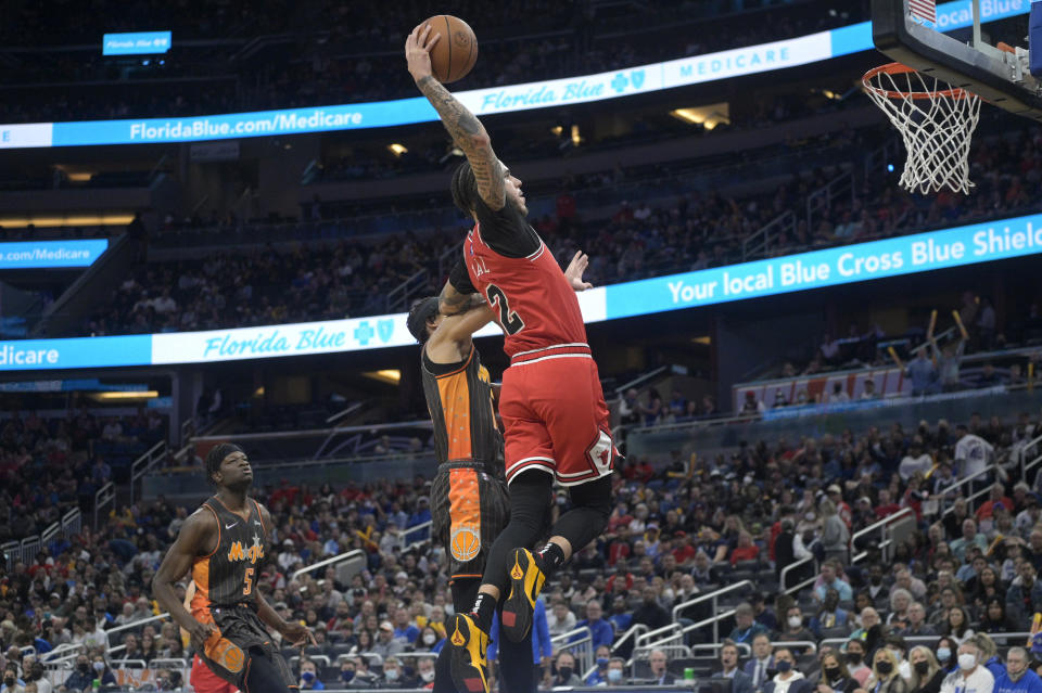 Chicago Bulls guard Lonzo Ball (2) goes up but misses on a dunk-attempt in front of Orlando Magic guard R.J. Hampton (13) as Magic center Mo Bamba (5) watches during the first half of an NBA basketball game, Friday, Nov. 26, 2021, in Orlando, Fla. (AP Photo/Phelan M. Ebenhack)