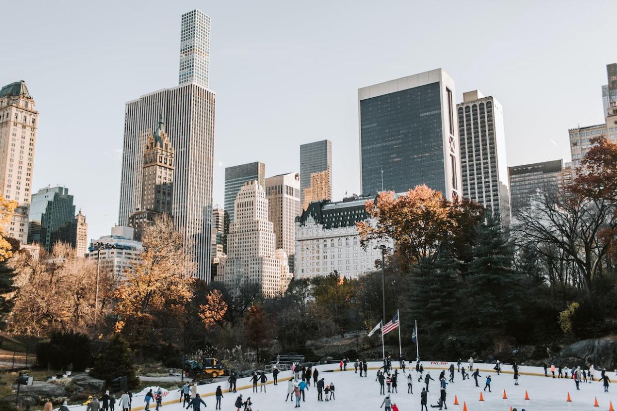 Check out this list of the top 10 most expensive cities in the world. Pictured: an ice skating rink with skyscrapers in the back in NYC.