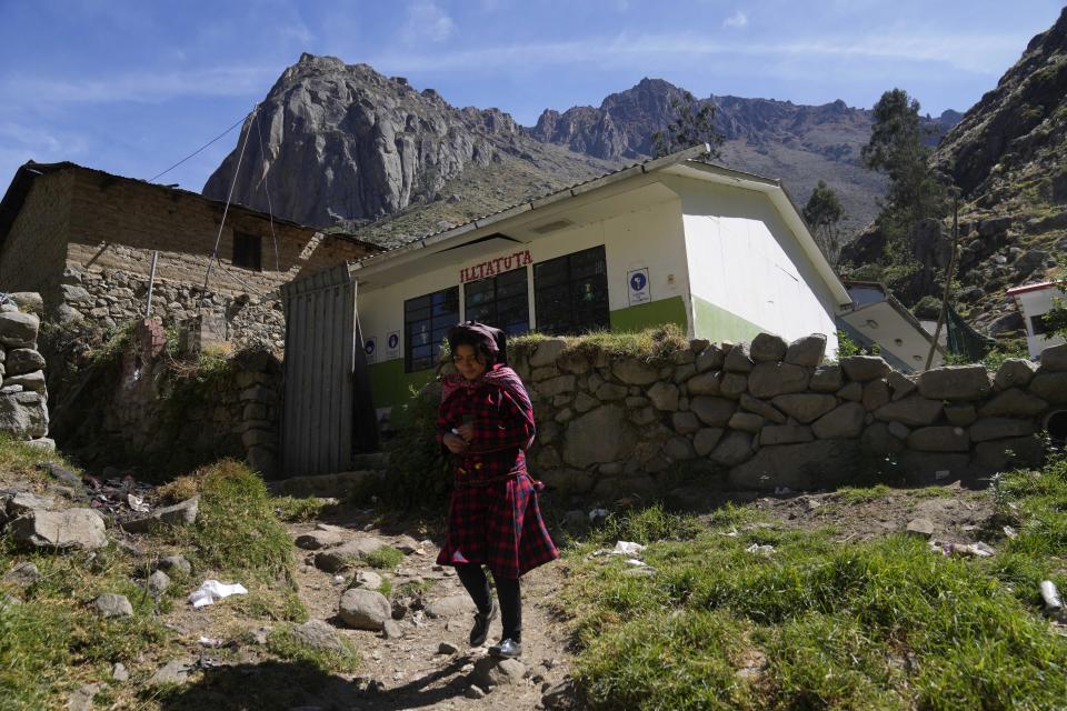 A girl walks past the school, with its name that reads "House of Awakening" in the Jaqaru Indigenous language, in Tupe, Peru, Tuesday, July 19, 2022. As Peru´s President Pedro Castillo marks the first anniversary of his presidency, his popularity has been decimated by his chaotic management style and corruption allegations, but in rural areas like Tupe, voters believe the fault for the executive crisis lies not only with Castillo, but with Congress, which has sought to remove him twice. (AP Photo/Martin Mejia)