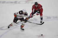 Anaheim Ducks' Cam Fowler (4) and Washington Capitals' Tom Wilson (43) battle for the puck during the first period of an NHL hockey game, Monday, Dec. 6, 2021, in Washington. (AP Photo/Luis M. Alvarez)