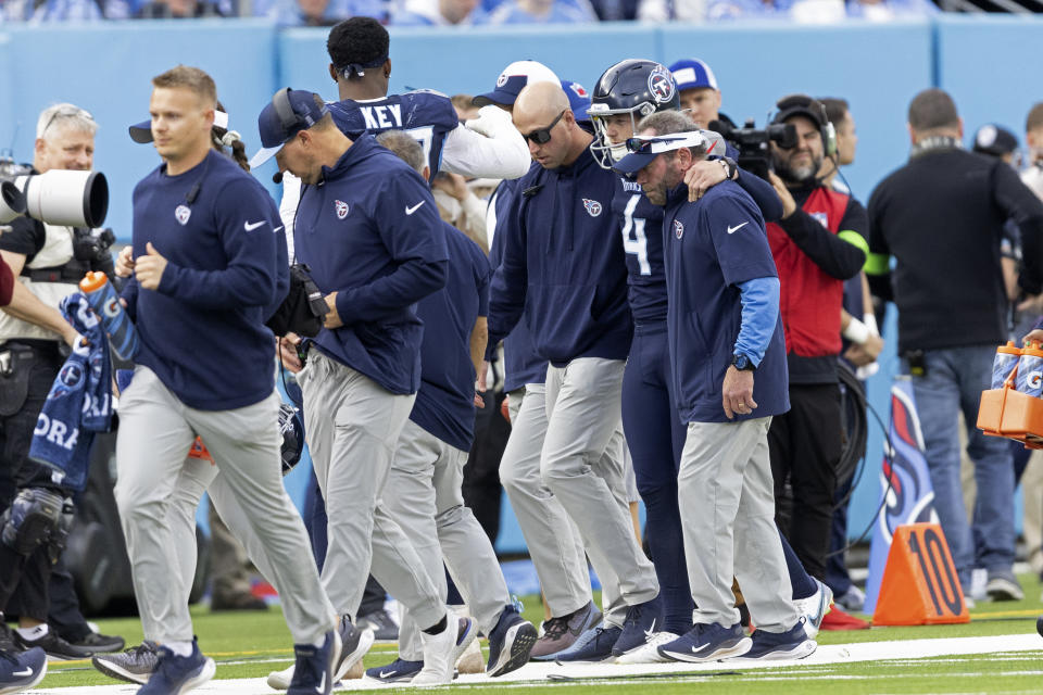 FILE - Tennessee Titans punter Ryan Stonehouse (4) is helped from the field after being injured on a play during their NFL football game against the Indianapolis Colts Dec. 3, 2023, in Nashville, Tenn. Tennessee coach Mike Vrabel announced Monday, Dec. 4, the firing of special teams coordinator Craig Aukerman after the Titans had a punt blocked and returned for a touchdown followed by Stonehouse's season-ending injury on his next punt attempt. (AP Photo/Wade Payne, File)