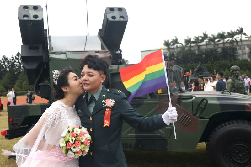 Chen Ying-Hsuan, a combat engineer lieutenant, and her wife Li Chen-Chen, take a photo in front of a AN/TWQ-1 Avenger mobile air defence system at a military mass wedding in Taoyuan