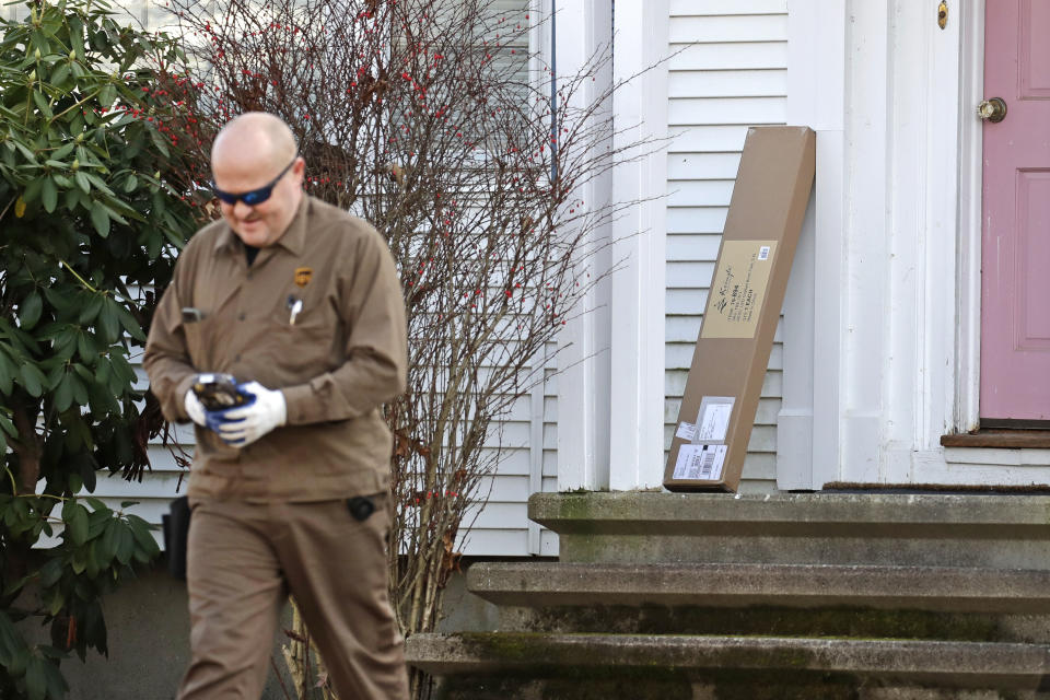 In this Nov. 26, 2019, photo a UPS man delivers a package to a residence in North Andover, Mass. “Cyber Monday” is still holding up as the biggest online shopping day of the year, even though the same deals have been available online for weeks and the name harks back to the days of dial-up modems. (AP Photo/Elise Amendola)