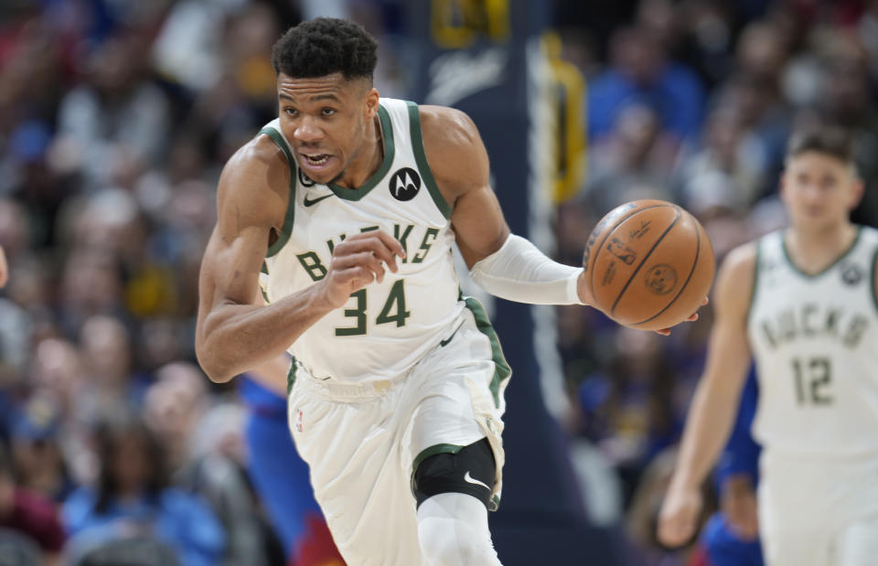 Milwaukee Bucks forward Giannis Antetokounmpo picks up a loose ball in the second half of an NBA basketball game against the Denver Nuggets Saturday, March 25, 2023, in Denver. (AP Photo/David Zalubowski)