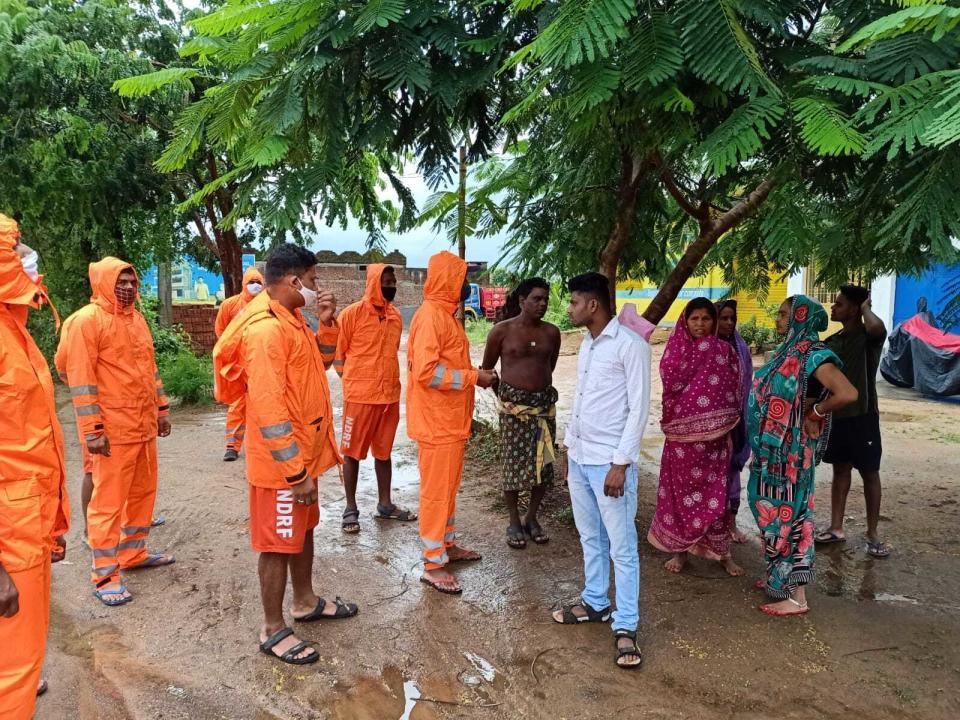 This Photograph provided by India's National Disaster Response Force (NDRF) shows NDRF personnel asking villagers to take precautions against Cyclone Gulab, that likely to make landfall on Sunday evening at Ganjam, eastern Odisha state, India, Sunday, Sept.26, 2021. (National Disaster Response Force via AP)