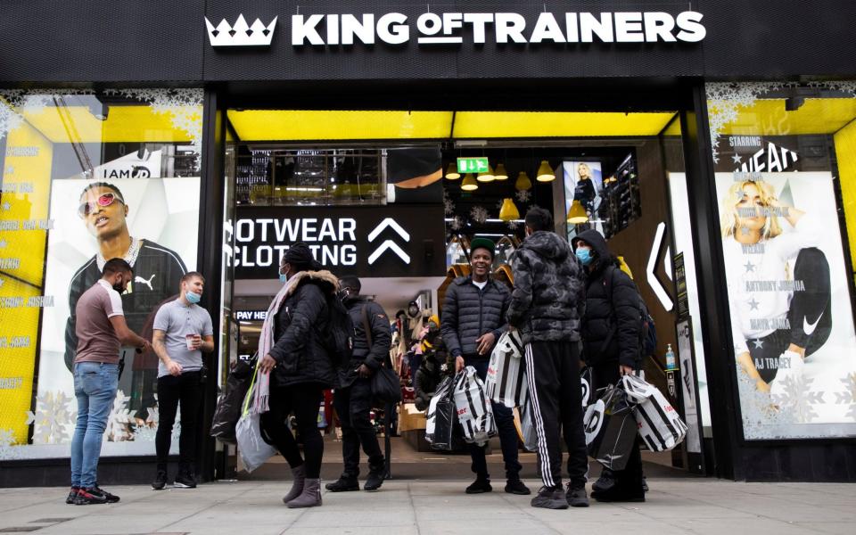  Shoppers depart a branch of JD sports on Oxford Street. - London News Pictures Ltd 