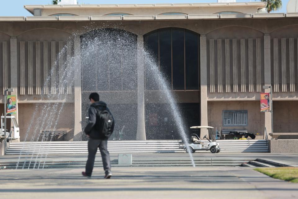 A student walks by the fountain in front of the administration building at College of the Desert.