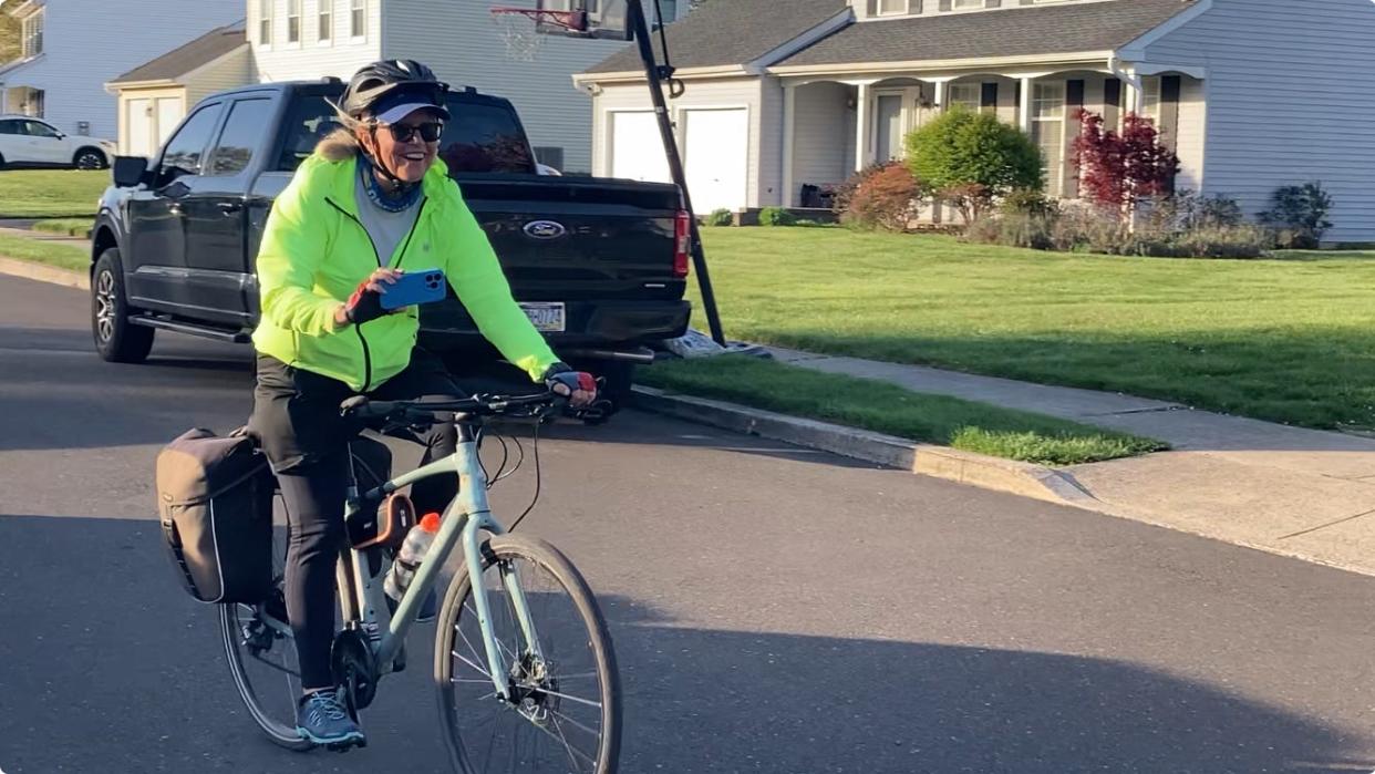 Debbie Curtis cruises up Lesha Drive in Falls to her brother's house after 3,600 mile bike ride across America. She completed her journey on Wednesday April 24, 2024 at the Statue of Liberty in New York.