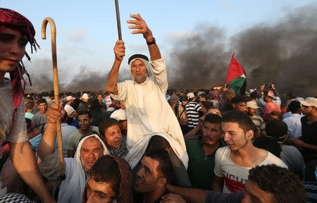 Palestinian demonstrators gather at the Israel-Gaza border fence during a protest calling for lifting the Israeli blockade on Gaza and demanding the right to return to their homeland, in the southern Gaza Strip October 19, 2018. REUTERS/Ibraheem Abu Mustafa