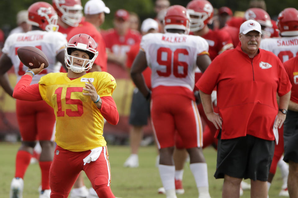 FILE - in this Aug. 2, 2019, file photo, Kansas City Chiefs quarterback Patrick Mahomes (15) throws as coach Andy Reid watches during NFL football training camp in St. Joseph, Mo. Mahomes is expected to get a series or two with the rest of the starters during a preseason game against the Cincinnati Bengals. (AP Photo/Charlie Riedel, File)