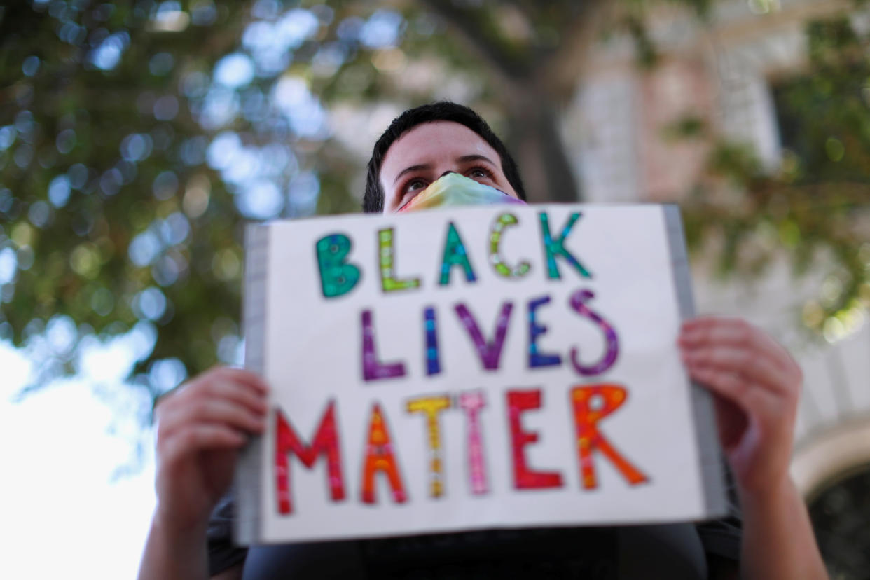 Demonstrator holds a sign during a Black Lives Matter rally protesting the death in Minneapolis police custody of George Floyd and the deaths of Kendrec McDade, Leroy Barnes and JR Thomas by Pasadena police, outside the Pasadena Police Department in Pasadena, California June 4, 2020. (REUTERS/Mario Anzuoni)