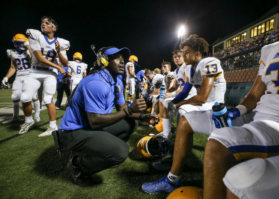 Carmel High School assistant coach Deion Branch talks with players on the sidelines during the game against Trinity. Branch was a standout receiver for the University of Louisville  before playing at New England and Seattle, earning a Super Bowl MVP. Aug. 20, 2021