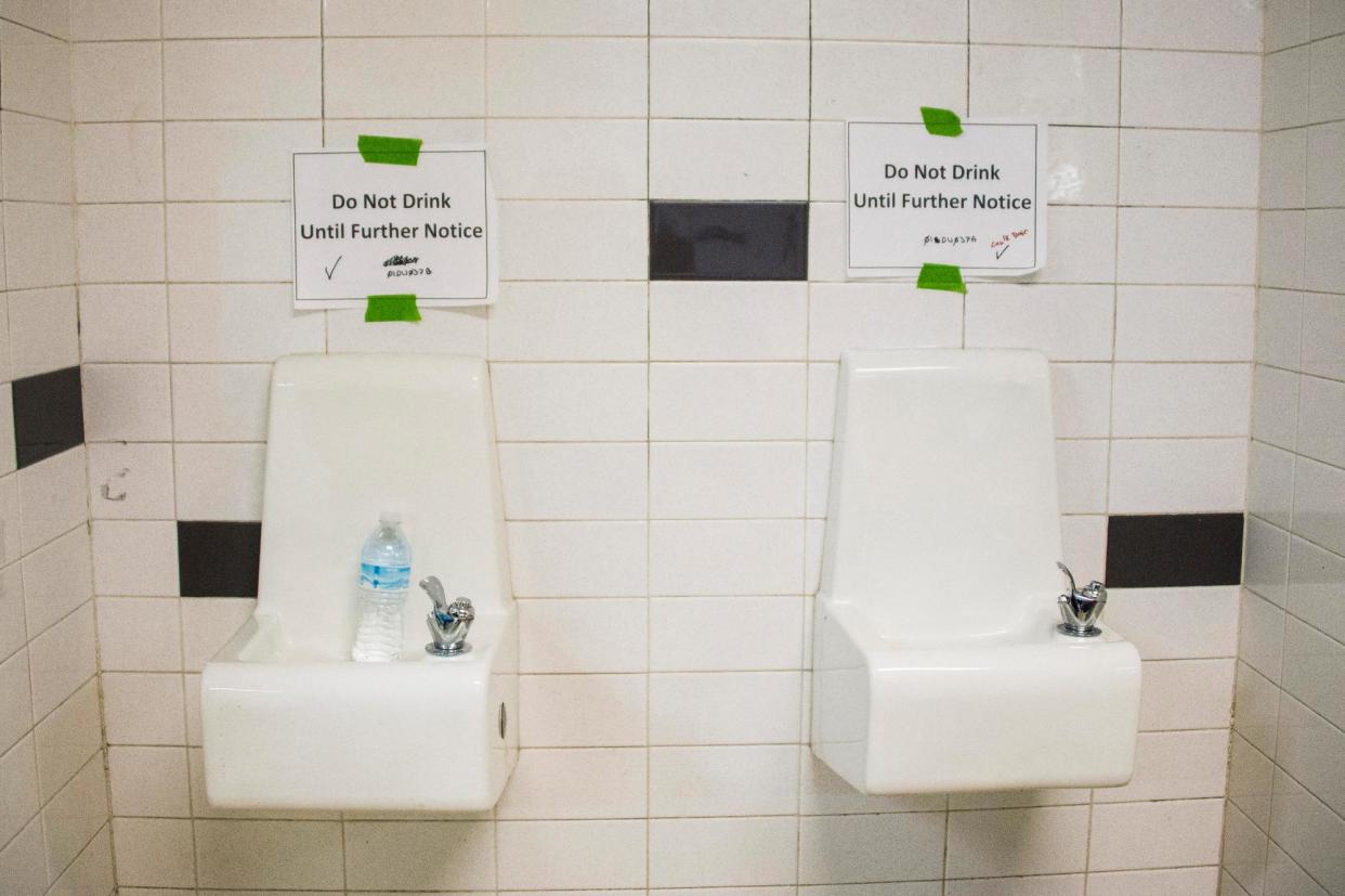 <span>Placards posted above water fountains warn against drinking the water at Flint Northwestern high school in Flint, Michigan, on 4 May 2016.</span><span>Photograph: Jim Watson/AFP via Getty Images</span>