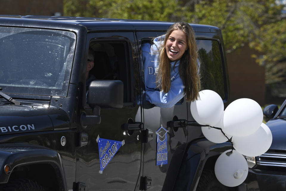 South River High School Class of 2020 senior Ashley Reed, 17, of Edgewater Md., waits for the start of a community-organized parade that began in the school parking lot in Edgewater, Saturday, April 25, 2020. Many of the South River High School families found ways to celebrate their seniors given that prom, graduation and other traditional senior activities were canceled. (AP Photo/Susan Walsh)