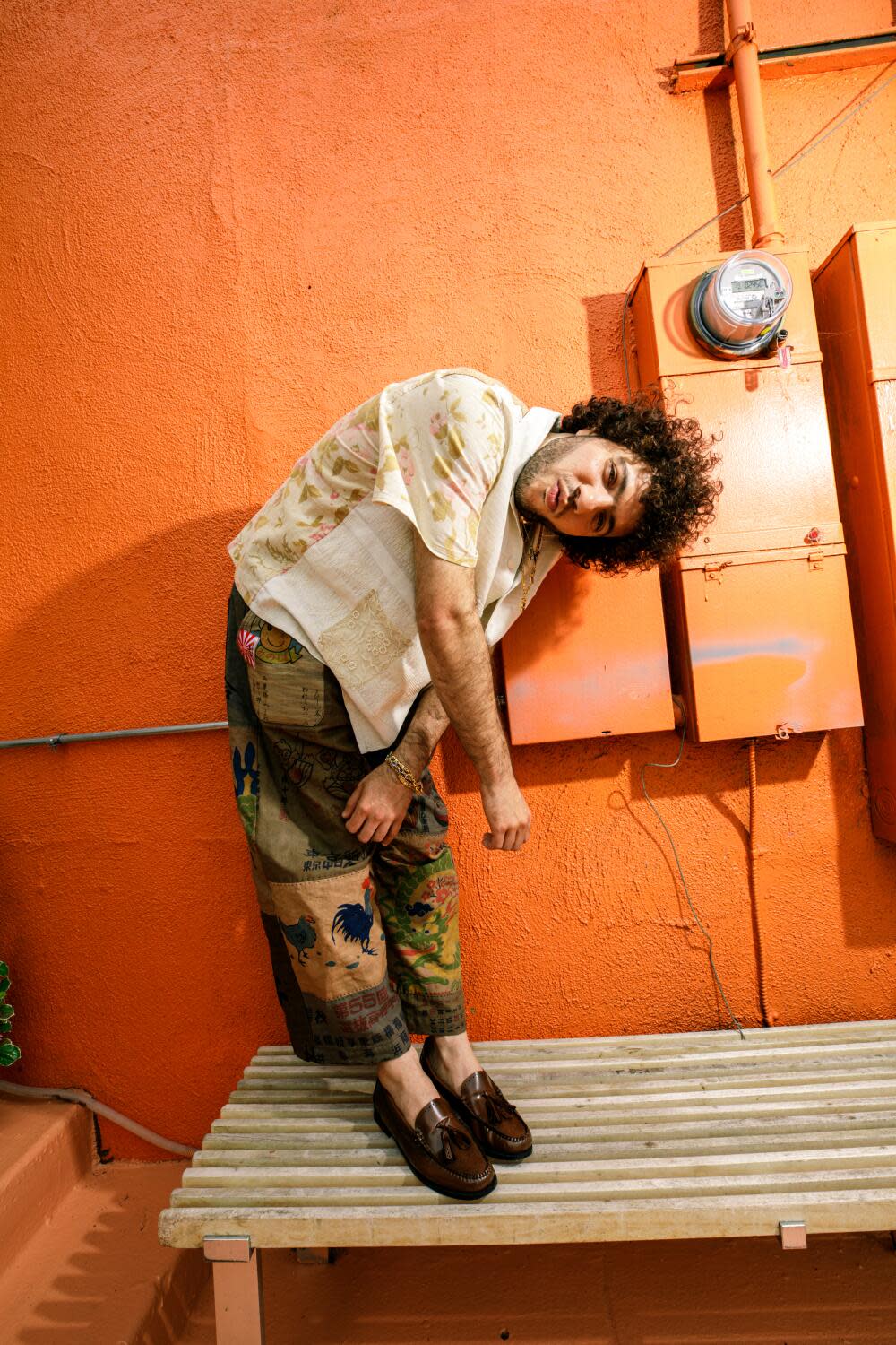 Benny Blanco poses for a portrait against an orange wall.