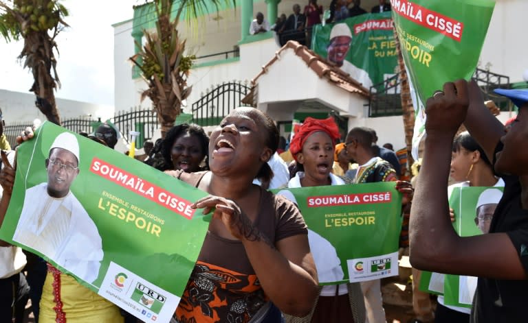 Supporters of Malian opposition leader and presidential candidate Soumaila Cisse hold posters reading "Together, let's restore hope"