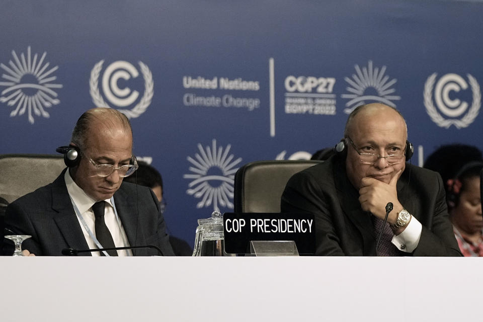 Wael Aboulmagd, special representative of COP presidency, left, listens with Sameh Shoukry, president of the COP27 climate summit, at the summit, Friday, Nov. 18, 2022, in Sharm el-Sheikh, Egypt. (AP Photo/Nariman El-Mofty)