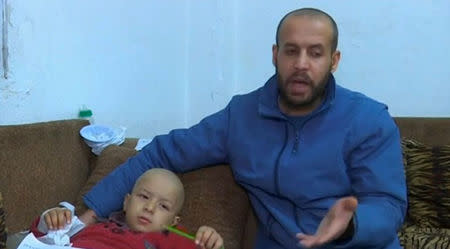 Syrian Refugee Jihad Alkhaled speaks to a reporter beside his son Mohammad, who suffers from Ewing Sarcoma and would need expensive chemotherapy sessions, in their home in Amman, Jordan, January 29, 2017. REUTERS Video News