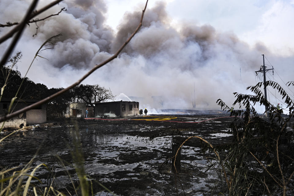 Smoke continues to billow from a days-long, deadly fire at a large oil storage facility in Matanzas, Cuba, Tuesday, Aug. 9, 2022. The fire was triggered by lighting at one of the facility's eight tanks late Friday, Aug. 5th. (Yamil Lage, Pool photo via AP)