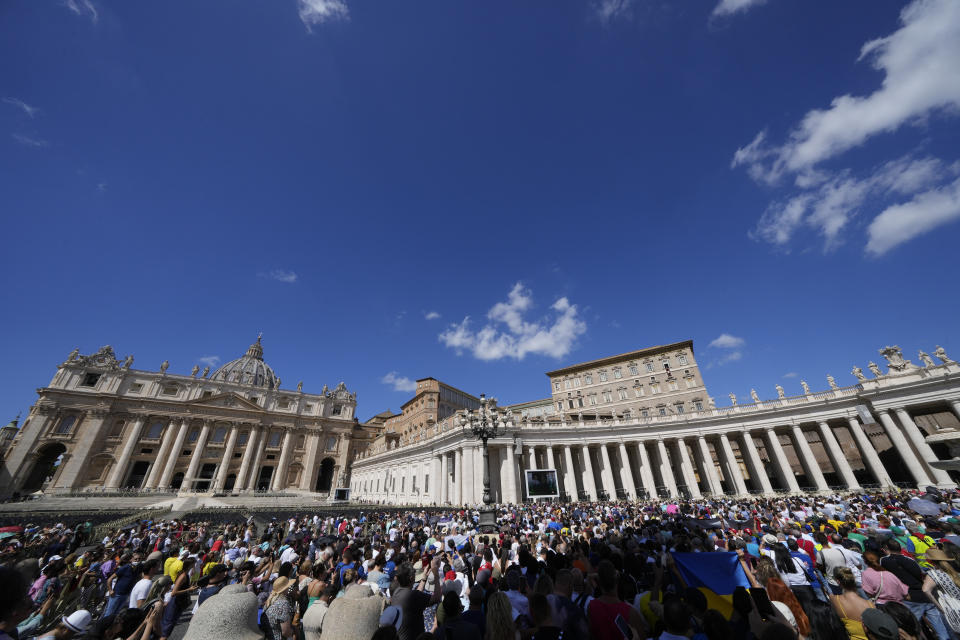 People gather as Pope Francis recites the Angelus noon prayer from the window of his studio overlooking St.Peter's Square, at the Vatican, Sunday, Sept. 11, 2022. (AP Photo/Andrew Medichini)