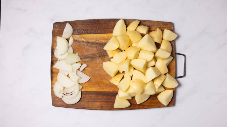 onions and potatoes on wooden board 