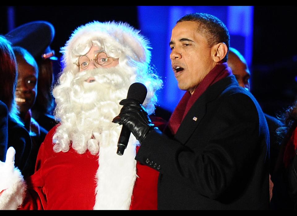 U.S. President Barack Obama sings with Santa Claus during the 2011 National Christmas Tree Lighting Ceremony on The Ellipse near the White House in Washington, D.C, on December 1, 2011. (Photo credit should read JEWEL SAMAD/AFP/Getty Images)  