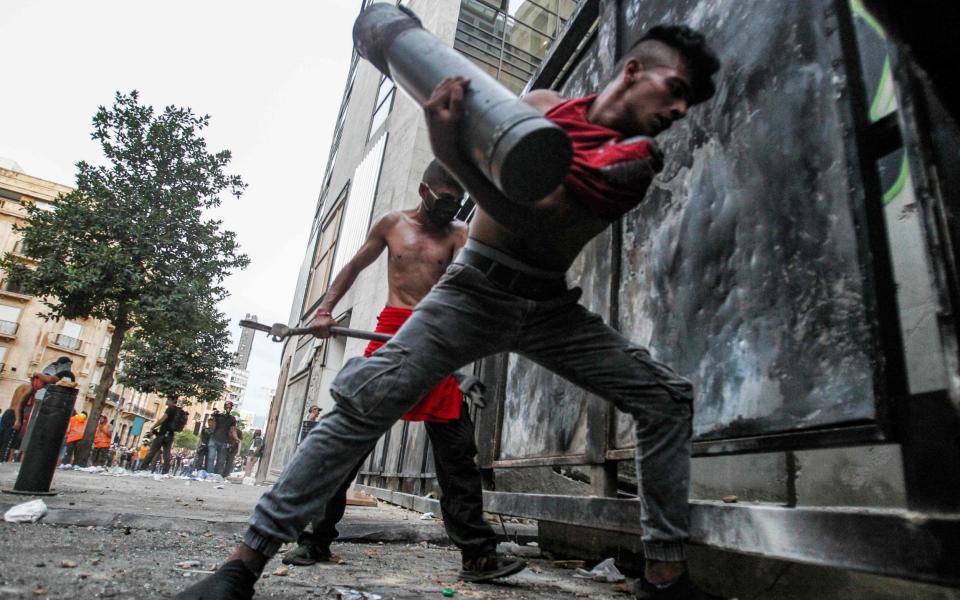 Lebanese protesters try to break through a barrier amid clashes with security forces in the vicinity of the parliament building in the centre of Beirut - IBRAHIM AMRO /AFP