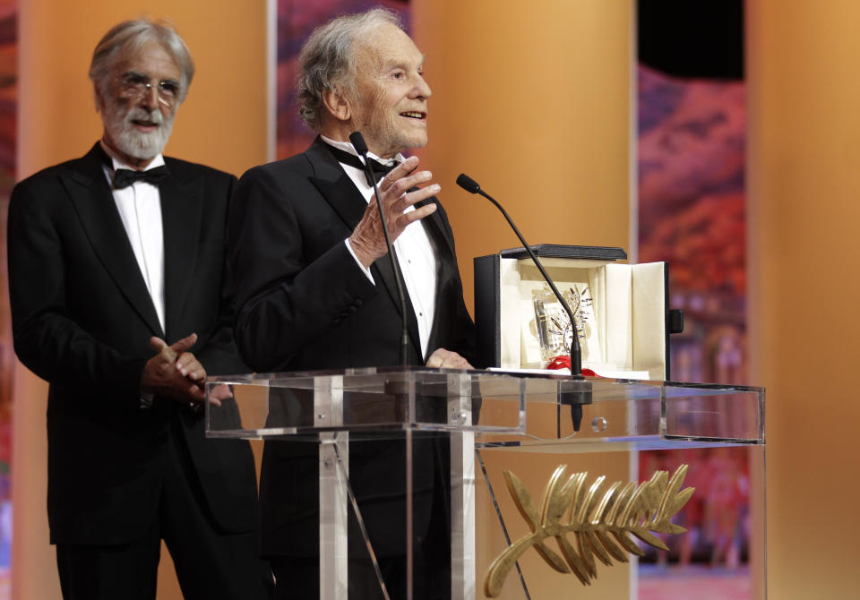 FILE - Actor Jean-Louis Trintignant speaks, right, as director Michael Haneke looks on after he is presented with the Palme d'Or award for Love during the awards ceremony at the 65th international film festival, in Cannes, southern France, Sunday, May 27, 2012. French film legend and amateur racecar driver Jean-Louis Trintignant, who earned acclaim for the Oscar-winning "A Man and a Woman" a half a century ago and went on to portray the brutality of aging in his later years, has died at 91. (AP Photo/Lionel Cironneau, File)