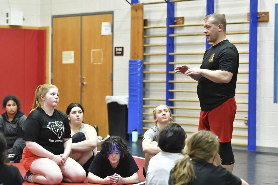 Aja'nail Jumper, front left, and teammates listen to coach Ryan Seagraves, right, at the end of a Cumberland Valley High School team practice Tuesday, Feb. 27, 2024, in Mechanicsburg, Pa. Jumper, a senior, began wrestling three years ago after the school started a girls' team. Before that, her parents had not wanted her to wrestle boys. (AP Photo/Marc Levy)
