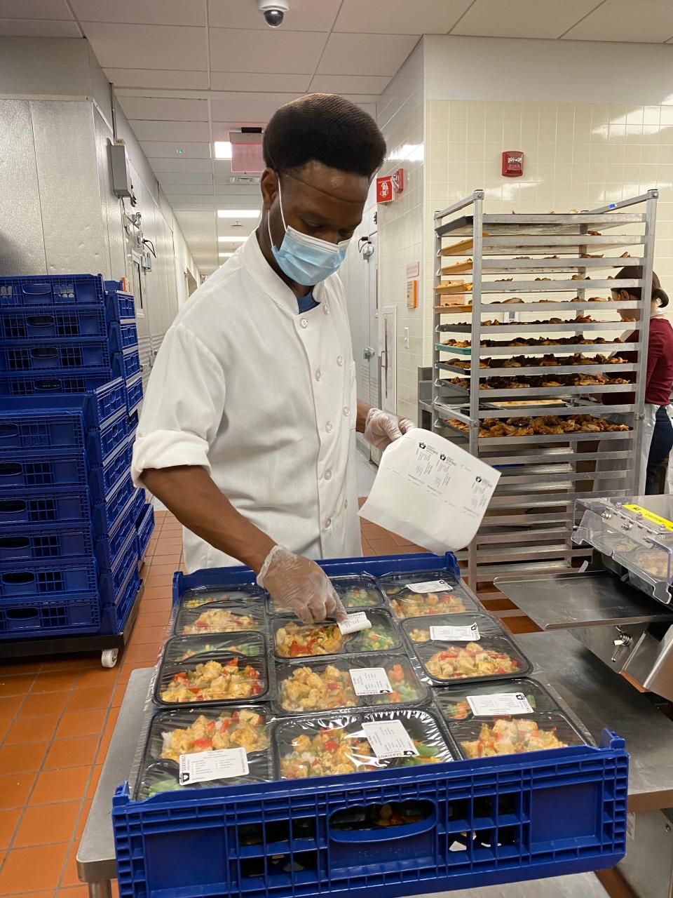 Community Servings Packing Association Nathan Legore labels meals to be sent to clients.