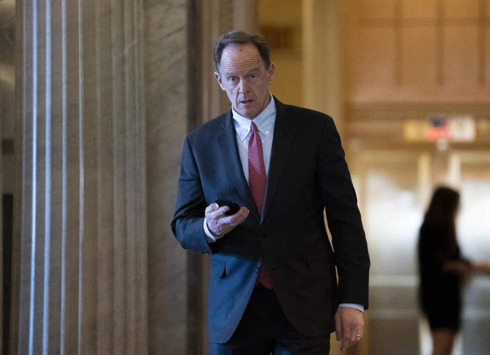 FILE - In this Feb. 3, 2020, file photo, Sen. Pat Toomey, R-Pa., walks at the Capitol in Washington. The nation's fiercest fiscal conservatives are largely embracing the massive economic rescue package moving through Congress. In many cases, those conservatives who support the $2 trillion coronavirus spending bill are the very same who raged against the $800 billion economic stimulus package backed by the Obama administration after the 2008 financial crisis. (AP Photo/J. Scott Applewhite, File)