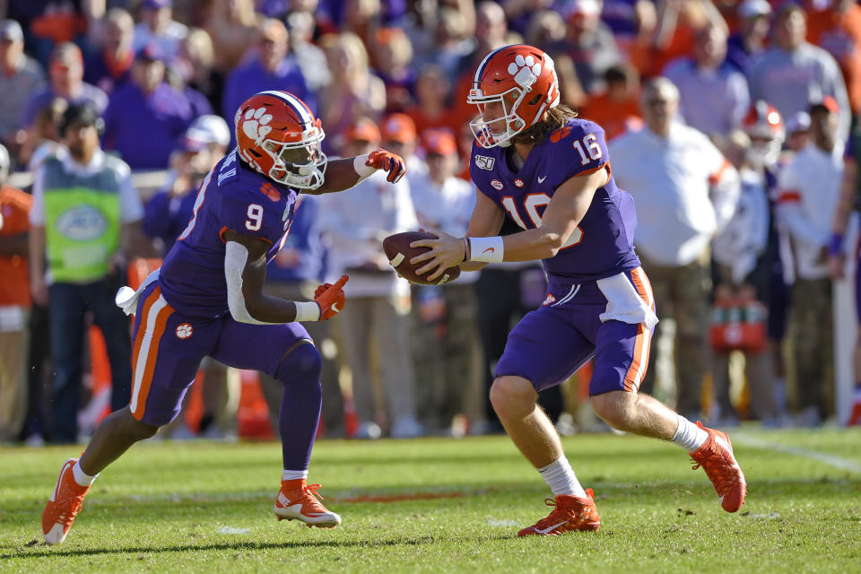 Clemson quarterback Trevor Lawrence (16) hands the ball off to running back Travis Etienne (9) during the first half of an NCAA college football game against Wofford, Saturday, Nov. 2, 2019, in Clemson, S.C. (AP Photo/Richard Shiro)