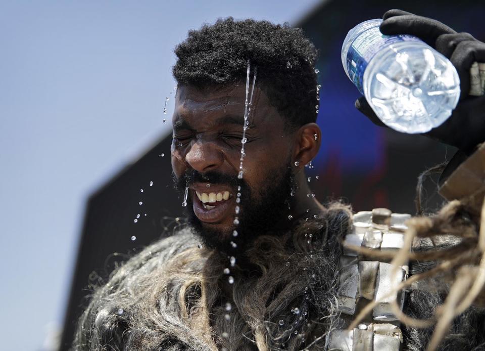 <p>Xaviere Coleman pours water over his head to cool off in a Wookiee costume along the Las Vegas Strip, June 20, 2017, in Las Vegas. Coleman was taking a break from posing for photographs with tourists. (John Locher/AP) </p>