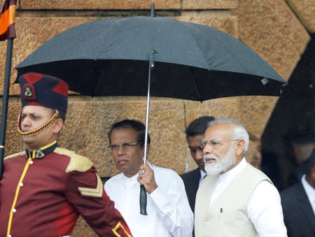 India's Prime Minister Narendra Modi arrives with Sri Lanka's President Maithripala Sirisena during his welcome ceremony at the Presidential Secretariat in Colombo