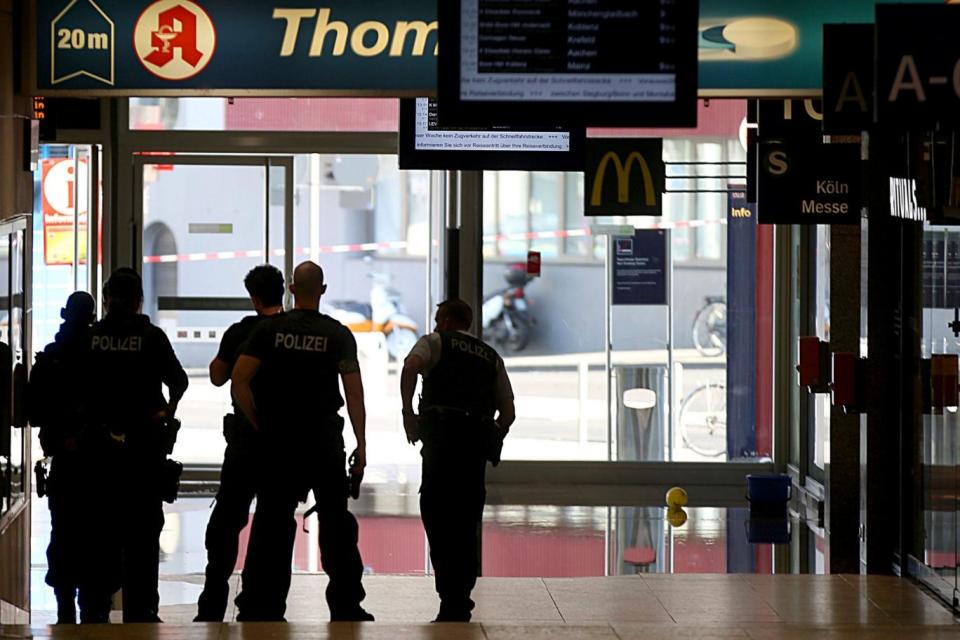 Police forces stand at the Cologne, western Germany, main station on Monday (AP)