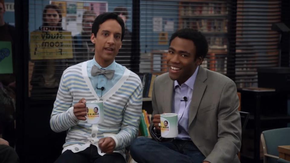 Troy and Abed holding coffee mugs on their imaginary talk show in "Community"