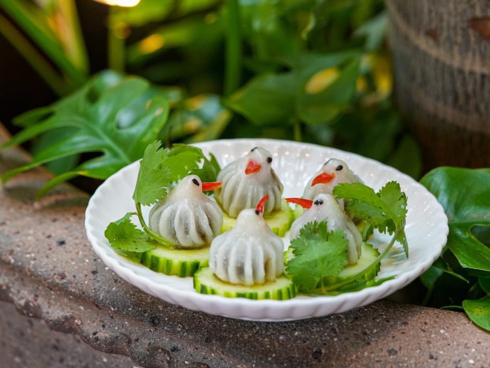 Bird-shaped dumplings sitting on a bed of cucumber slices at the Philadelphia restaurant Kalaya.