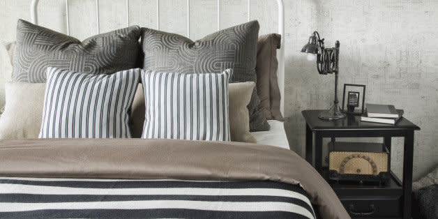 Striped and patterned pillows and blanket on bed