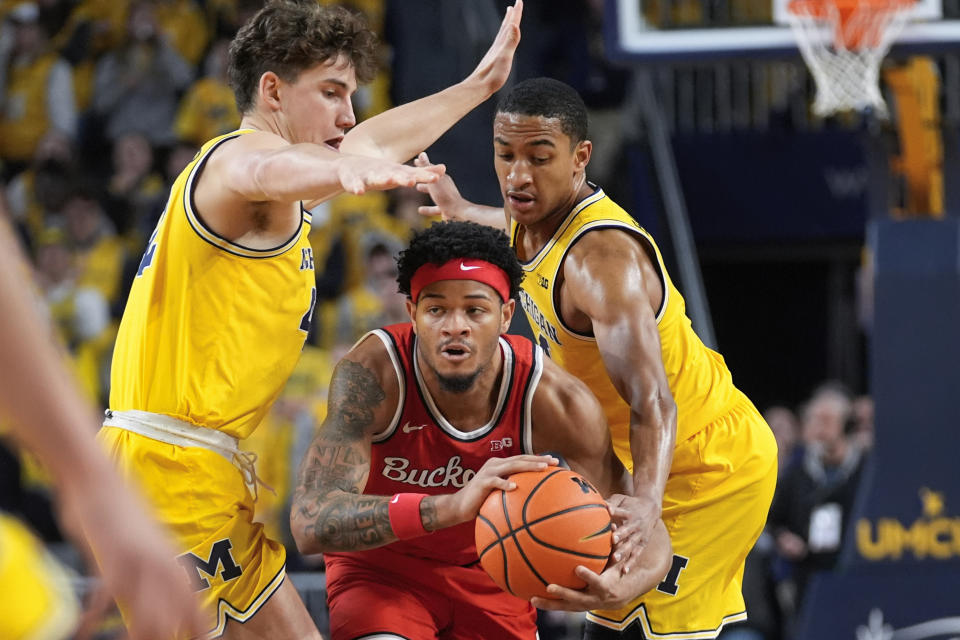 Ohio State guard Roddy Gayle Jr., center, is trapped by Michigan forward Will Tschetter, left, and Michigan guard Nimari Burnett, right, in the first half of an NCAA college basketball game in Ann Arbor, Mich., Monday, Jan. 15, 2024. (AP Photo/Paul Sancya)