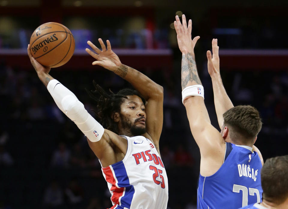 Detroit Pistons guard Derrick Rose (25) passes the ball as Dallas Mavericks forward Luka Doncic (77) defends during the first half of an NBA basketball game Wednesday, Oct. 9, 2019, in Detroit. (AP Photo/Duane Burleson)