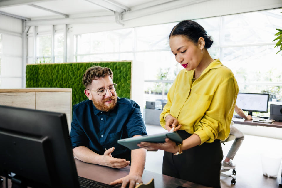 coworkers talking at a desk