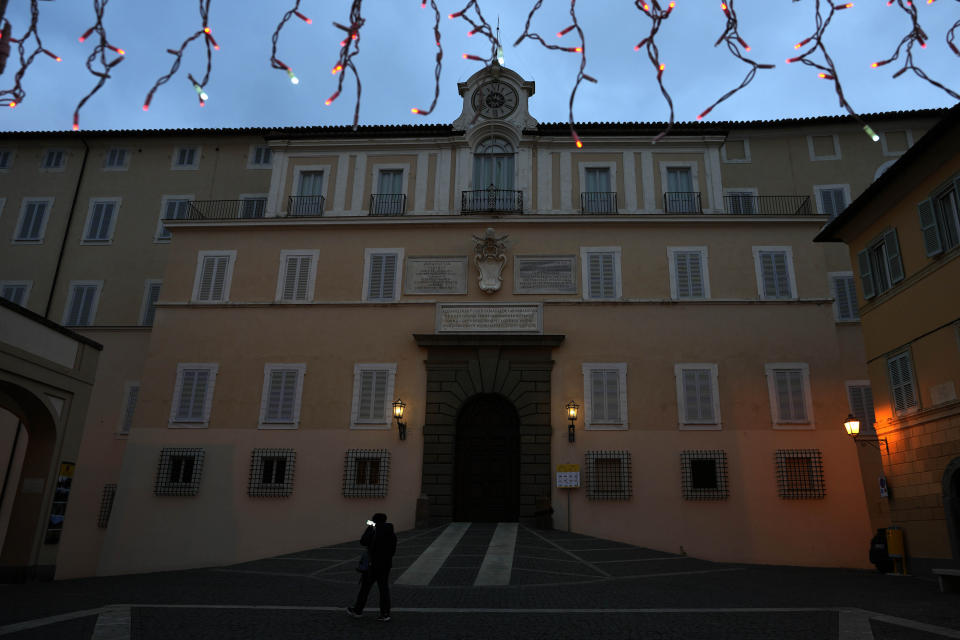 A man walks past the papal villa of Castel Gandolfo, in the hills south of Rome, Jan. 3, 2023. Benedict XVI's death has hit Castel Gandolfo's "castellani" particularly hard, since many knew him personally, and in some ways had already bid him an emotional farewell when he uttered his final words as pope from the palace balcony overlooking the town square. (AP Photo/Alessandra Tarantino)