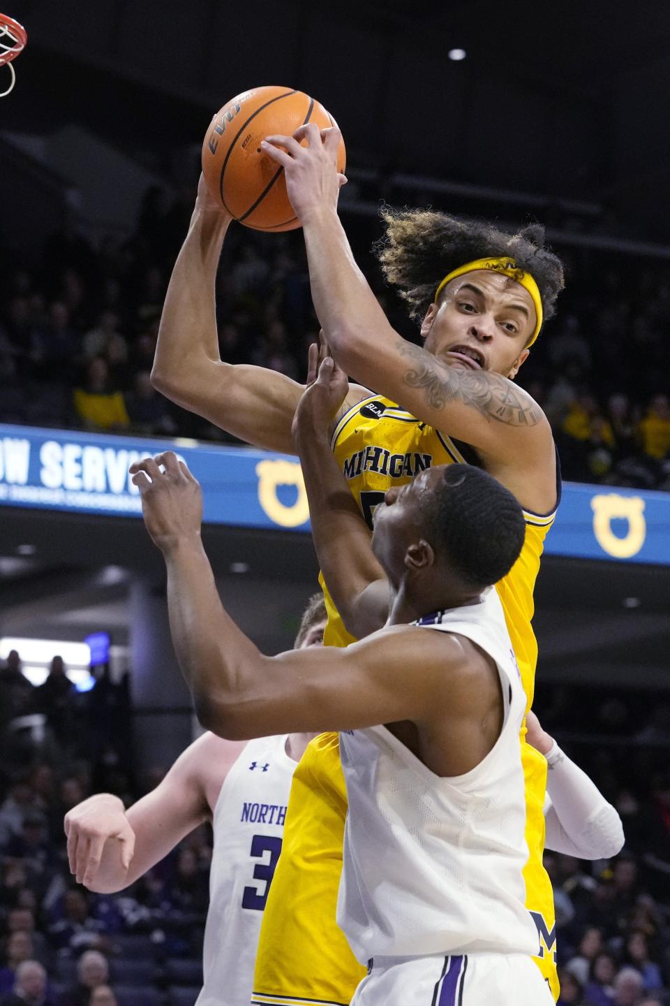 Michigan forward Terrance Williams II, top, rebounds the ball against Northwestern center Matthew Nicholson, left, and guard Chase Audige during the first half on Thursday, Feb. 2, 2023, in Evanston, Illinois.