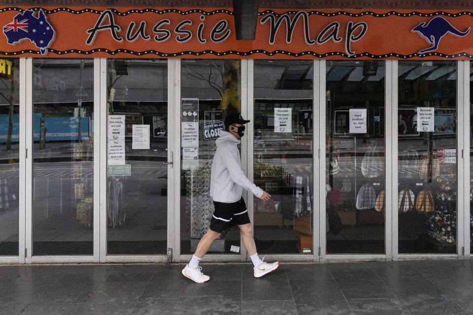 A man walks past a shop closed down store selling Australian paraphernalia items aimed at International tourists during lockdown in Melbourne, Australia, Wednesday, Aug. 5, 2020. Victoria state, Australia's coronavirus hot spot, announced on Monday that businesses will be closed and scaled down in a bid to curb the spread of the virus. (AP Photo/Asanka Brendon Ratnayake)