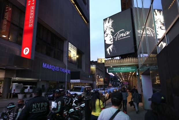 People walk through the theatre district in Manhattan on May 6. Gov. Andrew Cuomo announced last week that Broadway theatres can reopen at full capacity starting on Sept. 14. They have been closed since last spring due to the pandemic.  