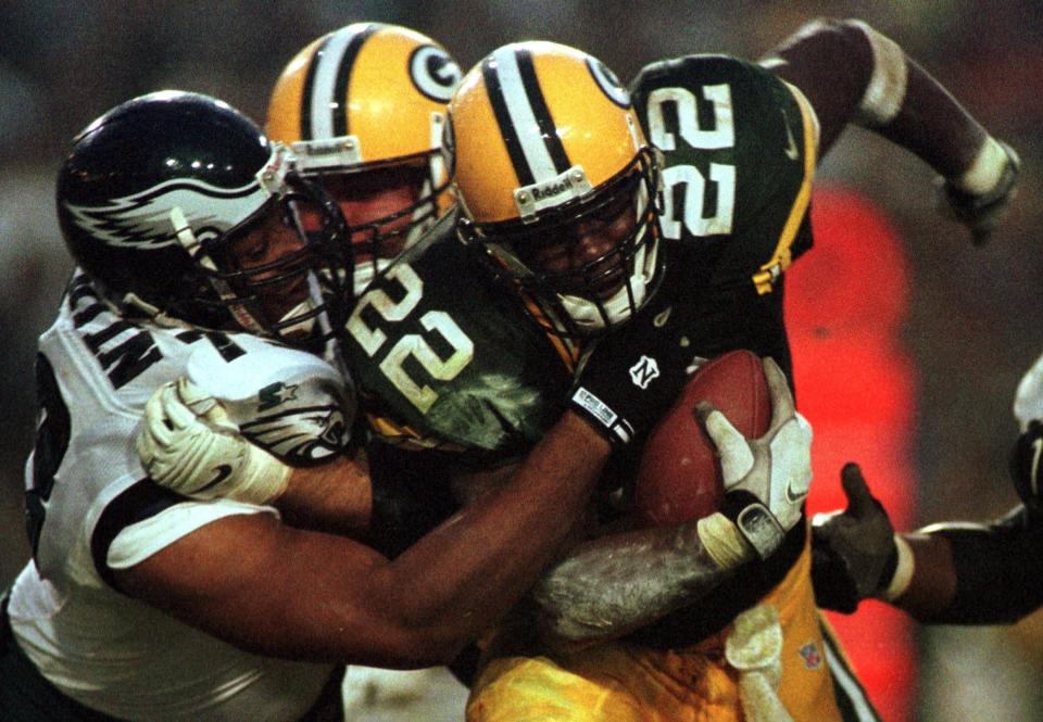 Green Bay packers running back Darick Holmes tries to bull his way for extra yardage while being grabbed by Philadelphia Eagles Steve Martin during the second quarter of their game Sunday, November 29, 1998 at Lambeau Field in Green Bay, Wis.