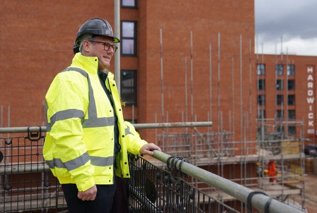 Sir Keir Starmer wearing a hard hat and hi-vis jacket on a building site