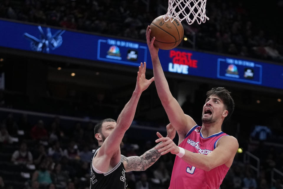 Washington Wizards forward Deni Avdija, right, goes up against San Antonio Spurs forward Sandro Mamukelashvili, left, during the first half of an NBA basketball game Friday, March 24, 2023, in Washington. (AP Photo/Carolyn Kaster)